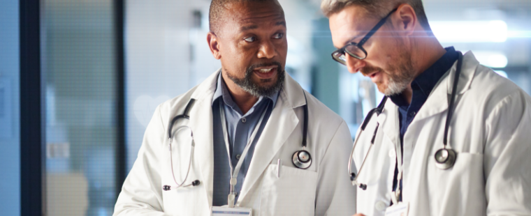 2 male physicians talking to each other in a hospital corridor